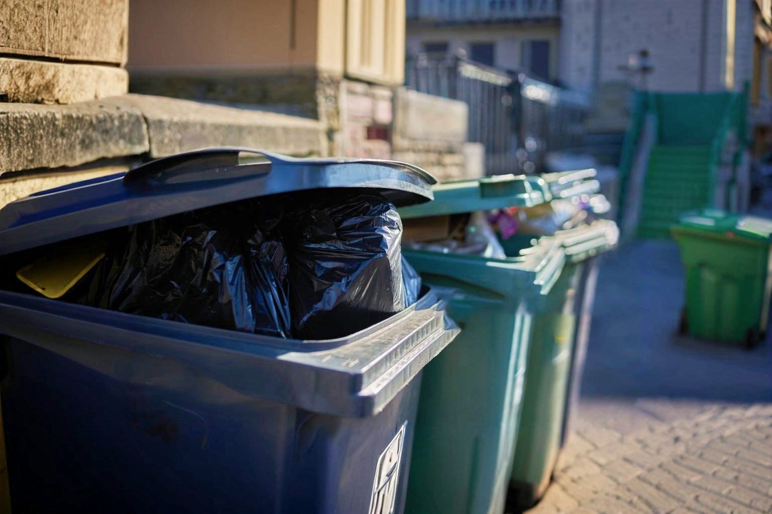 Residential recycling bins with plastic bag contamination