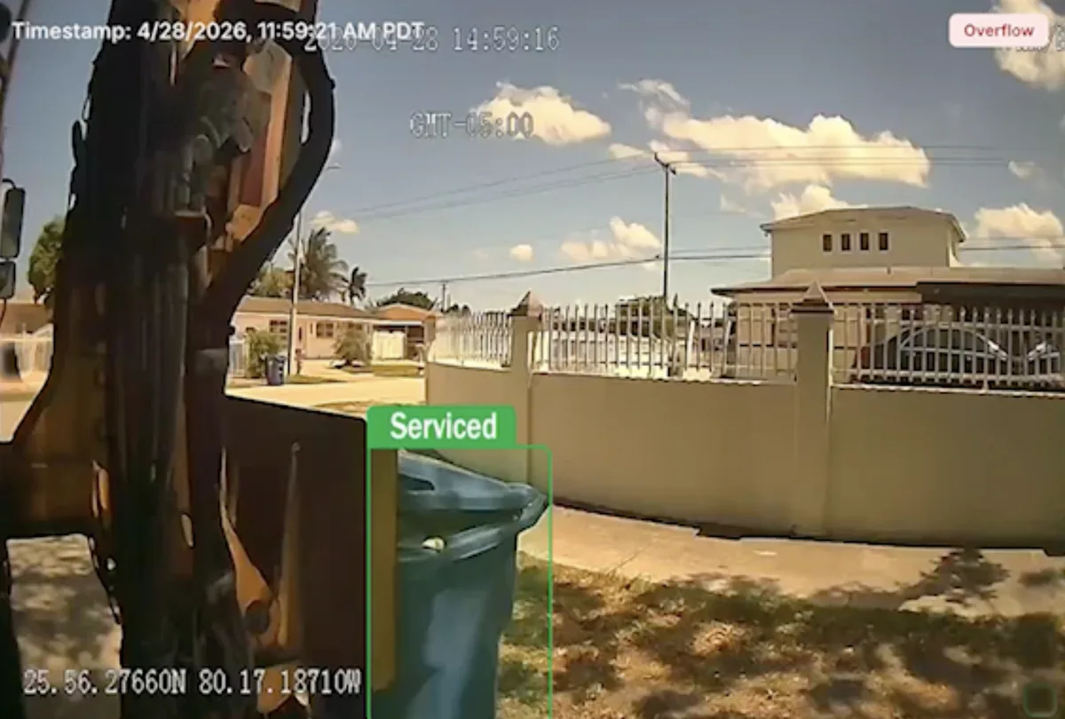 Camera capture from the truck: a bin at the curb tagged Serviced with an overflow flag, time-stamped 4/28/2026 11:59:21 AM with GPS coordinates